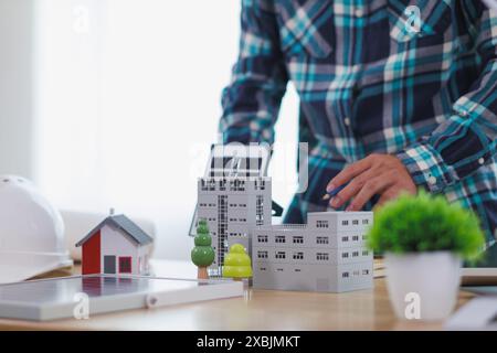 Les ingénieurs examinent les plans des architectes pour préparer l’installation de panneaux solaires et d’éoliennes sur le bâtiment afin de produire efficacement de l’électricité Banque D'Images