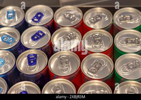 Des canettes de bière en métal coloré sont disposées sur une étagère en rangées symétriques Banque D'Images