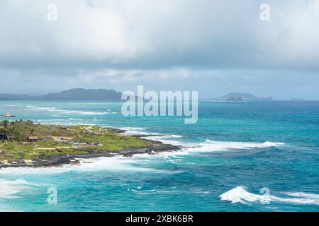 Une petite île est située au centre d'une vaste étendue d'eau, entourée d'un paysage naturel pittoresque sous un ciel rempli de nuages et d'un dis Banque D'Images