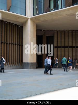 Employés de bureau à l'extérieur de l'entrée principale du siège social européen de Bloomberg Queen Victoria Street City de Londres Angleterre Royaume-Uni Banque D'Images