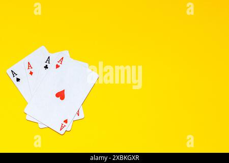 Un fan de cartes à jouer composé de quatre as isolés sur jaune Banque D'Images