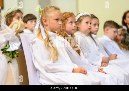 Les enfants dans les bancs de leur première communion Mass. Banque D'Images