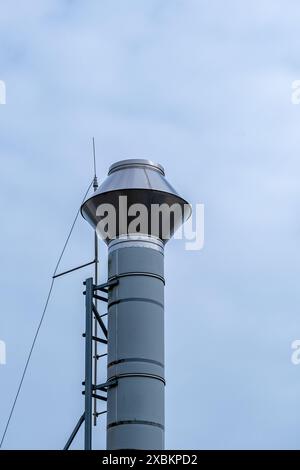 cheminée en acier argenté contre un ciel nuageux Banque D'Images