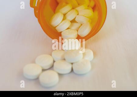 Metformine générique délivré à partir d'une pharmacie comprimés de 500 mg sur fond blanc. Regarde dans une bouteille orange de prescription. Banque D'Images