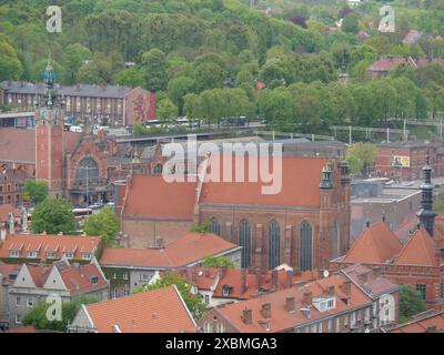 Vue sur la ville avec une vieille église et des bâtiments historiques en briques, entouré d'arbres verts et de toits rouges, Gdansk, Pologne Banque D'Images