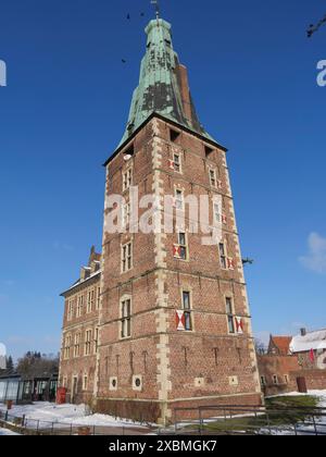 Une haute tour de briques du château en hiver avec un sol enneigé et un ciel bleu, Raesfeld, muensterland, Allemagne Banque D'Images