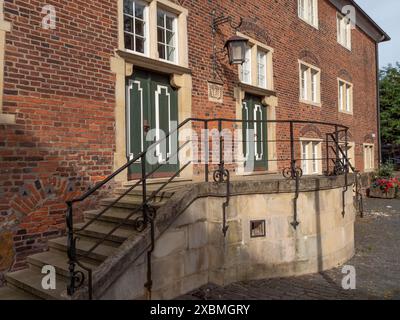 Vieille maison en briques avec portes vertes, fenêtres et escalier latéral avec balustrades en fer forgé, ramsdorf, muensterland, Allemagne Banque D'Images