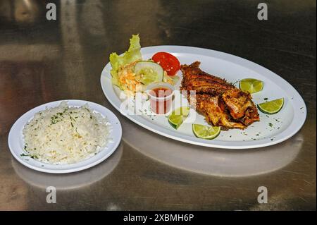 Plat de poisson poêlé avec poisson-lion envahissant des Caraïbes (Pterois miles) préparé sans nageoires de tête queue épines venimeuses prêtes à servir avec citron vert Banque D'Images