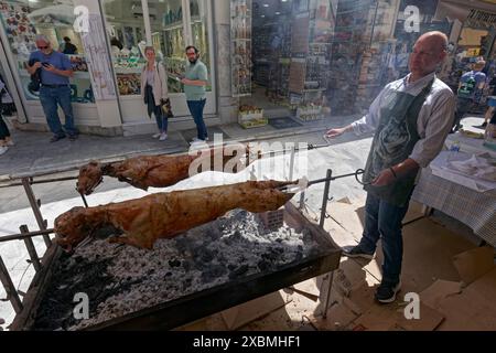 Homme griller des agneaux sur une broche devant une taverne, agneau de Pâques, quartier de Plaka, Athènes, Grèce Banque D'Images