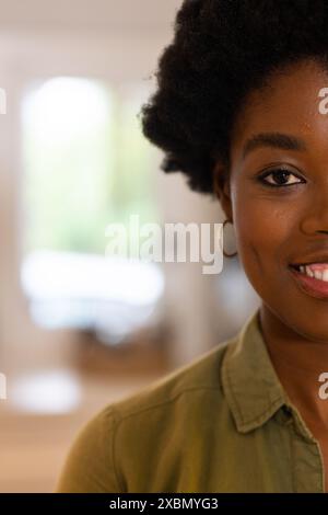 Femme afro-américaine souriant chaleureusement, à la maison Banque D'Images