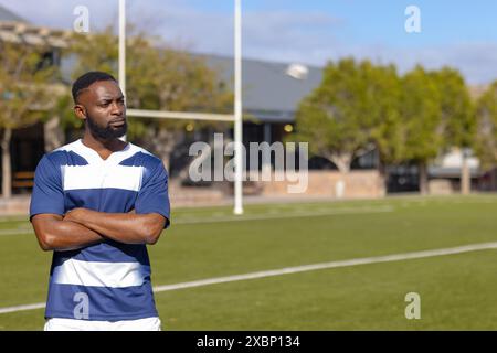 Joueur de rugby afro-américain debout fort et en forme sur le terrain de sport, espace de copie Banque D'Images
