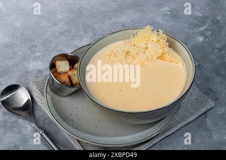 Soupe au fromage avec des croûtons sur un fond gris. Copier l'espace Banque D'Images