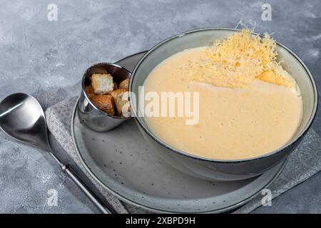 Soupe au fromage avec des croûtons sur un fond gris. Copier l'espace Banque D'Images