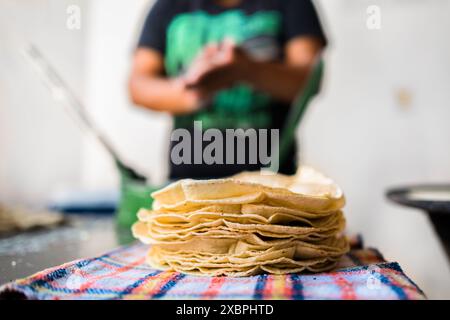 Un tas de tortillas fraîchement préparées est vu placé sur un tissu dans un tortillería à Morelia, Michoacán, Mexique. Banque D'Images