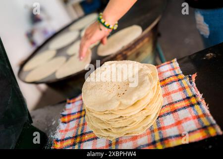 Un tas de tortillas fraîchement préparées est vu placé sur un tissu dans un tortillería à Morelia, Michoacán, Mexique. Banque D'Images