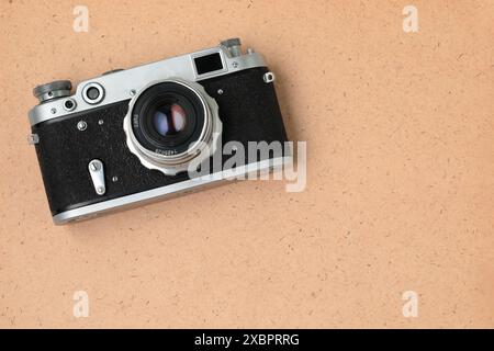 Appareil photo rétro sur vieux papier vintage avec une texture et un espace de copie, vue de dessus, concept de choses rétro Banque D'Images
