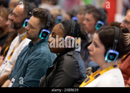 Les participants au salon professionnel écoutent le conférencier principal sur un casque Banque D'Images