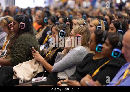 Les participants au salon professionnel écoutent le conférencier principal sur un casque Banque D'Images