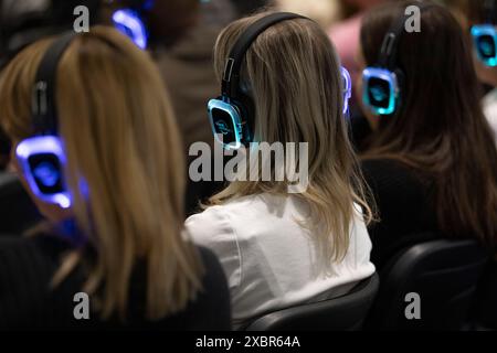 Les participants au salon professionnel écoutent le conférencier principal sur un casque Banque D'Images