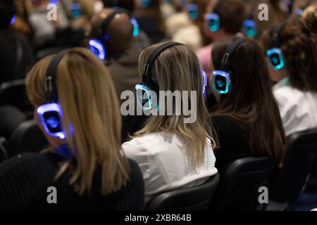 Les participants au salon professionnel écoutent le conférencier principal sur un casque Banque D'Images