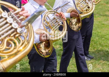 quatre musiciens d'affilée jouant du cor dans une fanfare lors d'un défilé en plein air Banque D'Images