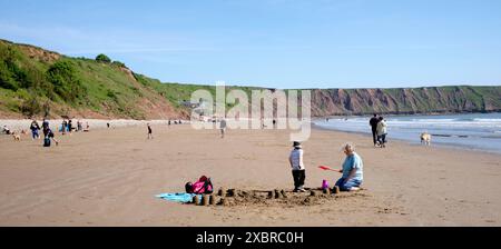 Grand-mère et petit-enfant appréciant la plage au large du Cobble Landing à Filey, North Yorkshire East Coast, nord de l'Angleterre, Royaume-Uni Banque D'Images