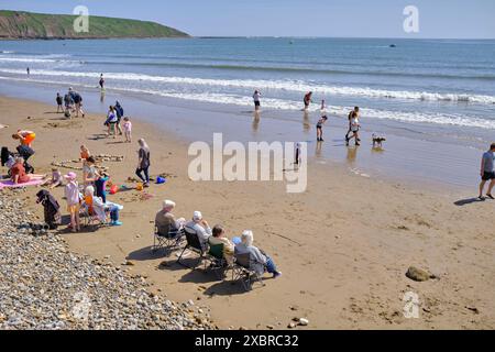 Quatre retraités se sont assis dans une rangée sur la plage au large du Cobble Landing à Filey, North Yorkshire East Coast, au nord de l'Angleterre, au Royaume-Uni Banque D'Images