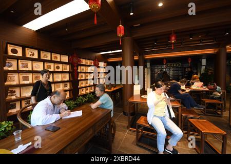 (240613) -- HANGZHOU, 13 juin 2024 (Xinhua) -- des gens attendent de voir un médecin dans une clinique de médecine traditionnelle chinoise dans le bloc historique et culturel de Qiaoxi le long du Grand canal à Hangzhou, dans la province du Zhejiang de l'est de la Chine, 12 juin 2024. Avec une histoire de plus de 2 500 ans, le Grand canal, reliant Pékin et Hangzhou dans la province du Zhejiang de l'est de la Chine, a servi d'artère de transport importante dans la Chine ancienne. Le canal a été classé au patrimoine mondial de l'UNESCO en Chine en juin 2014. Ces dernières années, les autorités locales ont donné la priorité à la protection du site tout en continuant à p Banque D'Images