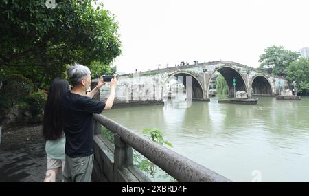 (240613) -- HANGZHOU, 13 juin 2024 (Xinhua) -- les visiteurs prennent des photos du pont Gongchen sur le Grand canal à Hangzhou, dans la province du Zhejiang, dans l'est de la Chine, le 12 juin 2024. Avec une histoire de plus de 2 500 ans, le Grand canal, reliant Pékin et Hangzhou dans la province du Zhejiang de l'est de la Chine, a servi d'artère de transport importante dans la Chine ancienne. Le canal a été classé au patrimoine mondial de l'UNESCO en Chine en juin 2014. Ces dernières années, les autorités locales ont donné la priorité à la protection du site tout en promouvant continuellement la protection du patrimoine culturel, la réutilisation de l’indus Banque D'Images