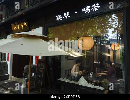 (240613) -- HANGZHOU, 13 juin 2024 (Xinhua) -- Une professeure joue du guqin, un instrument de musique traditionnel chinois à sept cordes pincées, avec son élève dans un studio de la rue Dadou, bloc historique et culturel le long du Grand canal à Hangzhou, province du Zhejiang, dans l'est de la Chine, 12 juin 2024. Avec une histoire de plus de 2 500 ans, le Grand canal, reliant Pékin et Hangzhou dans la province du Zhejiang de l'est de la Chine, a servi d'artère de transport importante dans la Chine ancienne. Le canal a été classé au patrimoine mondial de l'UNESCO en Chine en juin 2014. Ces dernières années, les autorités locales l'ont fait Banque D'Images