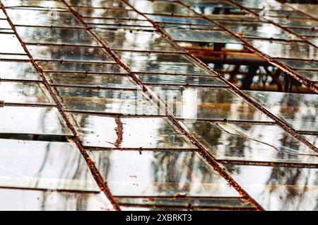 Verre brillant sur une serre abandonnée. Couverture sale de l'ancienne serre Banque D'Images