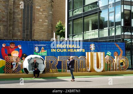 Les gens prennent une photo à un grand panneau dans le centre-ville de Dortmund accueille les visiteurs au Championnat d'Europe de football EURO2024, Dortmund est l'une des dix villes hôtes du Championnat d'Europe 2024 -- - Ein Großer Schriftzug in der Dortmunder City empfängt die Besucher zur Fußball-Europameisterschaft EURO2024, Dortmund ist einer der zehn Austragungsorte der Europameisterschaft 2024 Banque D'Images