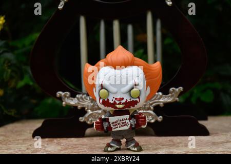 Funko Pop figurine d'action de Pennywise mal clown avec sanglant skateboard du film d'horreur il. Belvédère vintage miniature abandonné avec colonnes. Banque D'Images