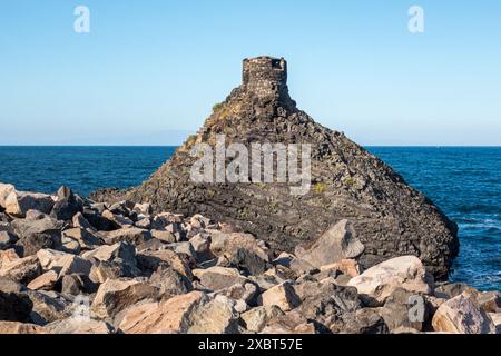 Un vieux fort ou tour de guet construit sur un affleurement de basalte volcanique dans le petit village de pêcheurs de Santa Maria la Scala, près d'Acireale, en Sicile Banque D'Images