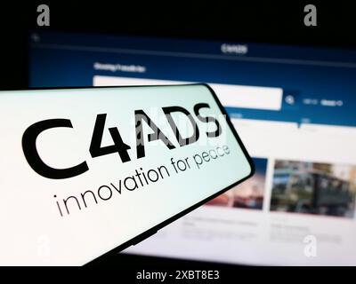 Téléphone portable avec le logo du Center for Advanced Defense Studies (C4ADS) devant le site Web. Mettez l'accent sur le centre-gauche de l'écran du téléphone. Banque D'Images
