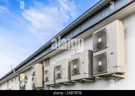 Rangée de doubles variateurs, combinaison de pompe de chauffage et de refroidissement, installés sur un bâtiment industriel Banque D'Images