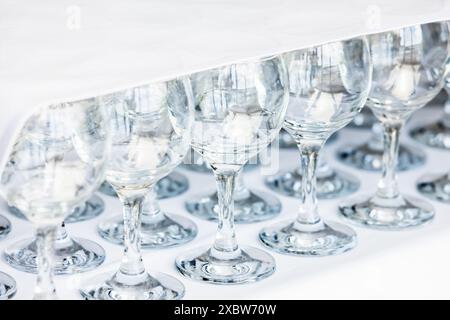 Les verres vides se tiennent sur une table recouverte d'une nappe blanche dans un restaurant Banque D'Images