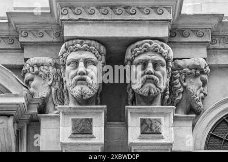 Détails architecturaux de la façade de l'église de San Raffaele avec des sculptures de têtes masculines, dans le centre-ville de Milan, Lombardie, Italie Banque D'Images