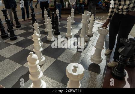 Les gens jouant aux échecs avec de grandes pièces sur le sol à l'extérieur du centre commercial Westfield à Stratford, Londres, Angleterre, Royaume-Uni Banque D'Images