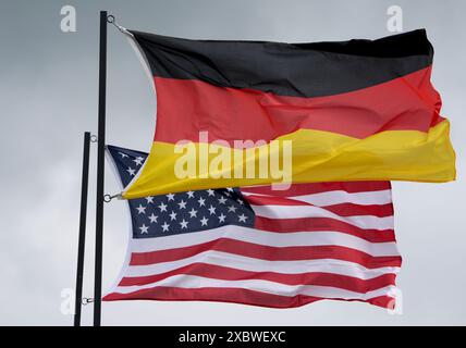 11 juin 2024, Schleswig-Holstein, Jagel : les drapeaux nationaux de l'Allemagne et des États-Unis d'Amérique agitent au vent dans une tribune pendant la manœuvre de l'armée de l'air de l'OTAN 'Tiger Meet' sur le terrain de l'escadre 51 de la Force aérienne tactique 'Immelmann'. Onze pays membres de l'OTAN, ainsi que la Suisse et l'Autriche, participent à l'exercice OTAN "Tiger Meet". Environ 60 avions et hélicoptères devraient y participer en juin. Environ 1100 soldats supplémentaires seront sur place. Tactical Air Force Wing 51 'Immelmann' célèbre son 30e anniversaire dans le cadre de cet exercice majeur. Photo : Marcus Brandt/dpa Banque D'Images