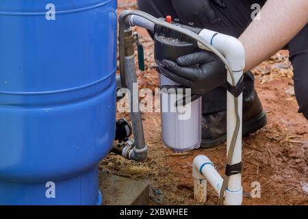 Les travaux d'entretien des travailleurs remplacent le filtre à eau de la ligne résidentielle de traitement de l'eau domestique Banque D'Images