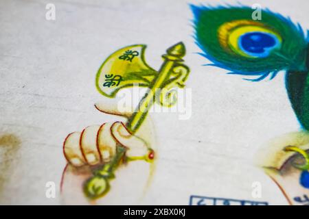 Viersen, Allemagne - 9 mai. 2024 : gros plan de la main de Ganesha tenant l'arme de hache de bataille Parashu sur une vieille peinture hindoue Banque D'Images