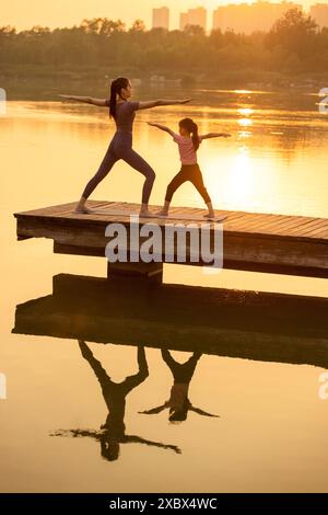 Maman et fille faisant du yoga dans Un parc Banque D'Images