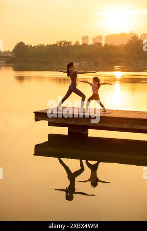 Maman et fille faisant du yoga dans Un parc Banque D'Images