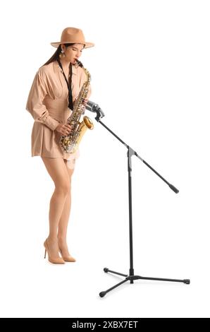 Belle femme avec microphone jouant du saxophone sur fond blanc Banque D'Images