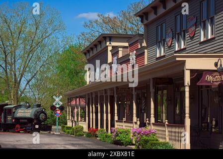 De vieilles boutiques avec une passerelle couverte et une locomotive à vapeur d'époque avec croisement de chemin de fer font partie du quartier historique d'Olmsted Falls Ohio. Banque D'Images
