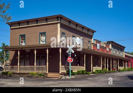 Un bloc de boutiques vintage avec une passerelle couverte et un signal de passage à niveau font partie du quartier du village sur le thème du chemin de fer. Banque D'Images