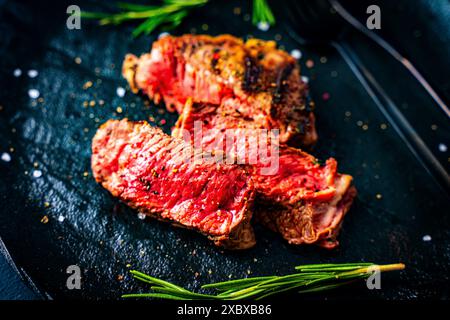 Barbecue grillé et tranché steak de viande de bœuf wagyu Rib Eye sur une assiette. Fond sombre. Vue de dessus. Photo de haute qualité Banque D'Images