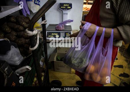 Buenos Aires, Argentine. 01 juin 2024. Un vendeur de légumes pèse des tomates cerises sur une balance. Les prix des denrées alimentaires ont augmenté de 4,8 pour cent en mai. L'augmentation annuelle des prix des denrées alimentaires dans ce pays d'Amérique du Sud est de 289,4 pour cent. Crédit : Cristina Sille/dpa/Alamy Live News Banque D'Images