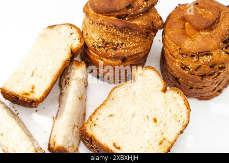 Gâteaux de Pâques faits maison aux raisins secs. Brioche entière et coupée en morceaux sur une table blanche. Photo de haute qualité Banque D'Images